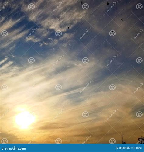 Odd Clouds Filling a Sky while Birds Fly Around Stock Image - Image of