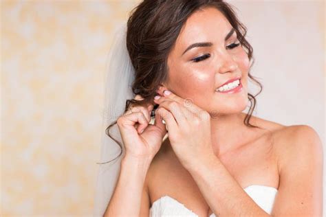 Elegant Bride Putting On Earrings Preparing For Wedding Stock Image