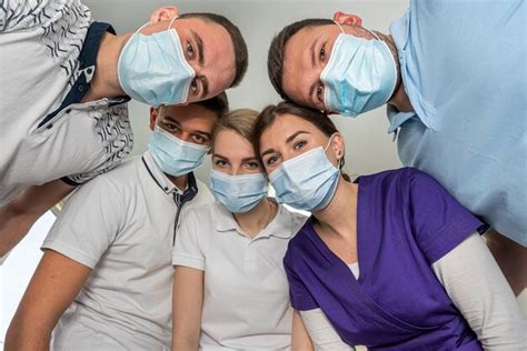 Grupo de médicos parados en un círculo con instrumentos médicos mirando