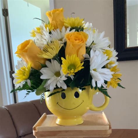 Yellow Smiley Face Vase With White And Yellow Flowers For New Baby