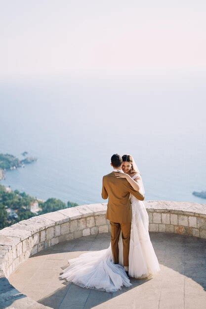 Premium Photo Bride And Groom Stand Hugging On The Observation Deck