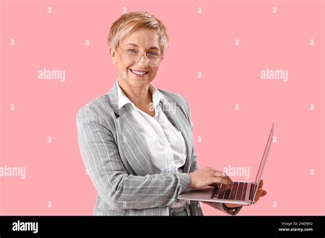 Mature Female Programmer Working With Laptop On Pink Background Stock