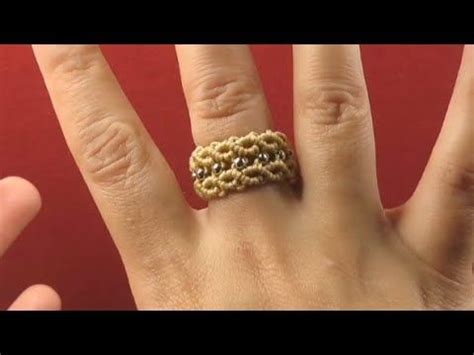 A Woman S Hand With A Ring Made Out Of Gold And Black Beads On It