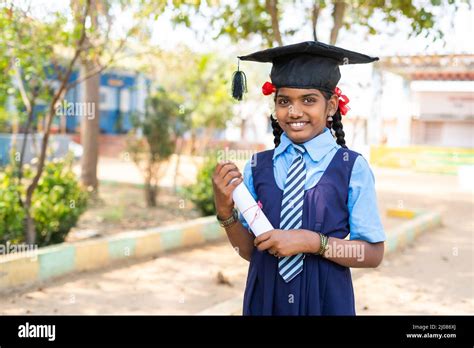 Happy girl kid in uniform standing by dreaming about graduation while ...