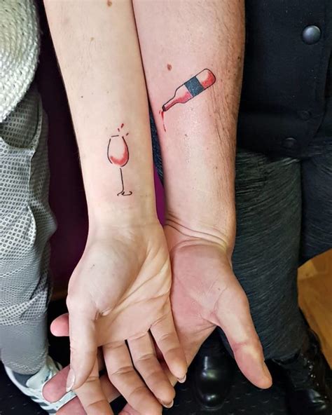 Two People Holding Hands With Tattoos On Their Arms One Has A Wine