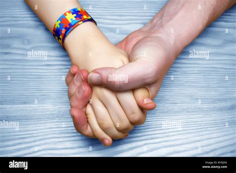 Autism Awareness Picture. Father holding hand her Autistic Child Stock Photo - Alamy