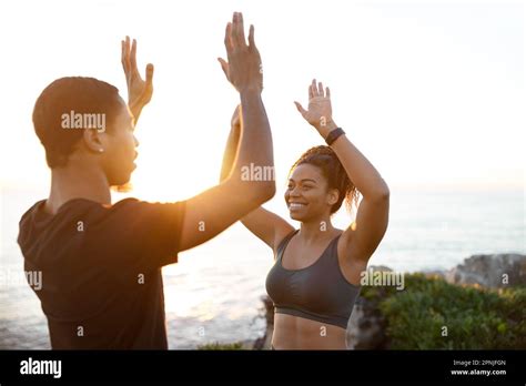 Glad Millennial African American Couple In Sportswear Give High Five On