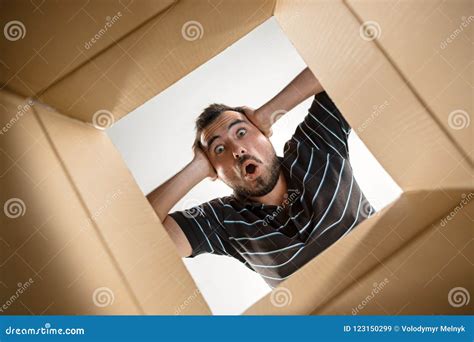 Man Unpacking And Opening Carton Box And Looking Inside Stock Image