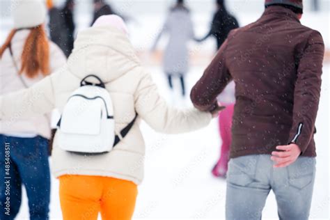 Couple In Love Skating On The Rink Holding Hands Blurred Background