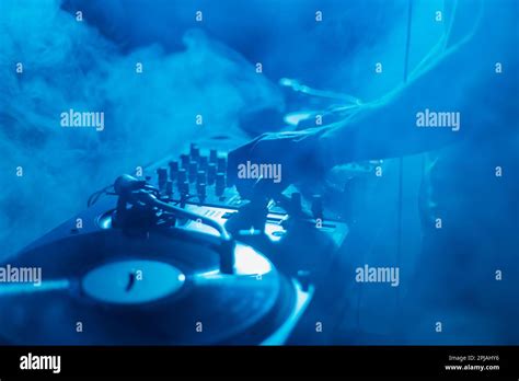 Silhouette Of A Club DJ Mixing Music In Smoke On Stage Professional