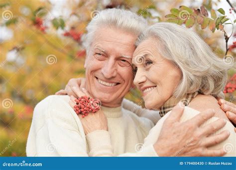 Portrait Of Beautiful Senior Couple Hugging In The Park With Rowan