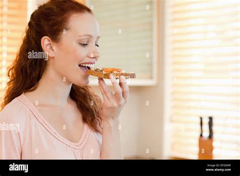 Side View Of Woman Biting Into Slice Of Bread Stock Photo Alamy