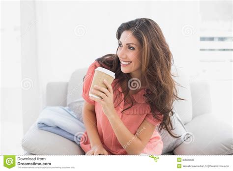 Happy Brunette Sitting On Her Sofa Holding Disposable Cup Stock Image Image Of Beautiful Calm