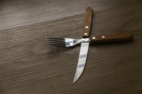 Food Concepthigh Angle View Of Crossing Knife Spoon On Wooden Table