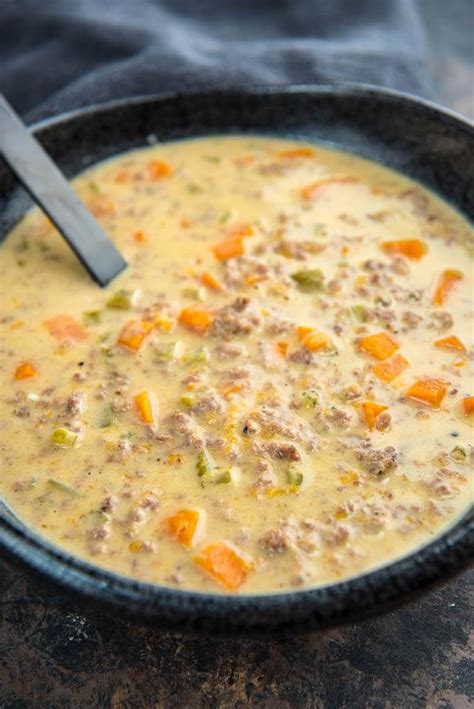 Black Bowl Full Of Slow Cooker Cheeseburger Soup With A Black Spoon