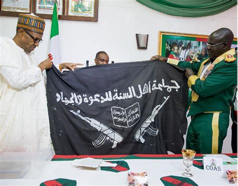 President Buhari Receives Captured Boko Haram Flag | BellaNaija