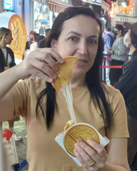 A Woman Eating Food From A Paper Plate