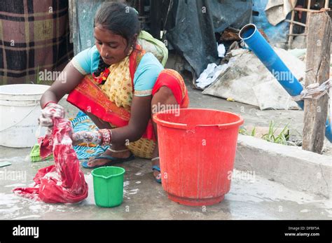 Portrait Of An Indian Woman Washing Clothes At A Homeless Camp In