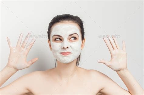 Perky Brunette With Cream Mask On The Face Naked Shoulders Rejuvenation