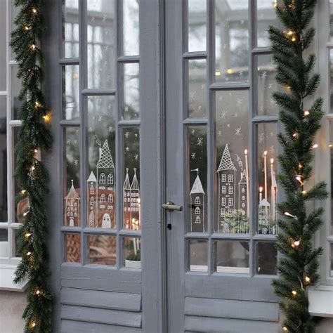 The Front Door Is Decorated For Christmas With Lights And Garlands On