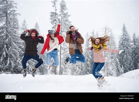 Friends Jumping In Snow Stock Photo Alamy