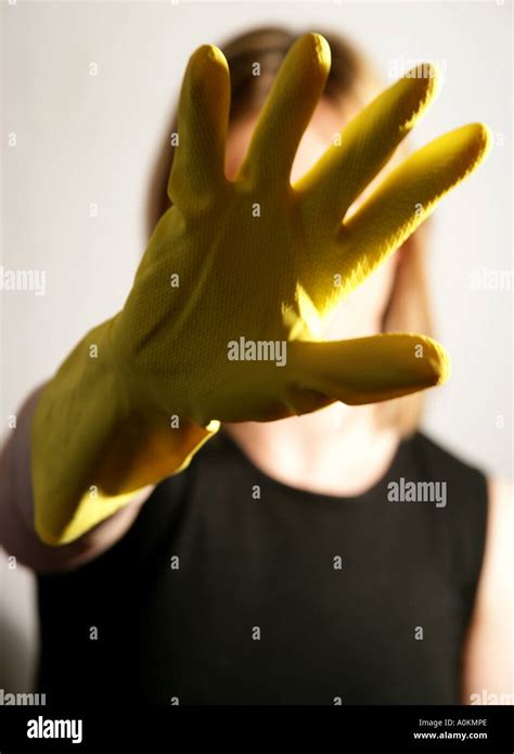 A Lone White Female Holding Up Her Yellow Rubber Gloved Hand In Front