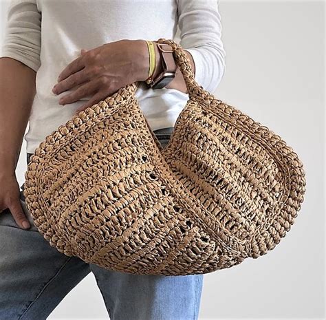 A Woman Is Holding A Woven Bag In Her Hands And The Bottom Half Of Her