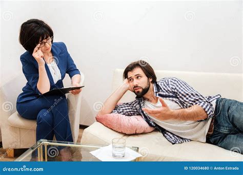 Man Is Lying On Sofa In White Room And Talking To Therapist He Is