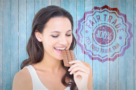 Composite Image Of Pretty Brunette Eating Bar Of Chocolate Stock Photo