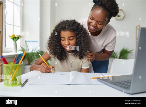 Une Jeune Mère Afro Américaine Heureuse Aide Sa Fille à Faire Ses