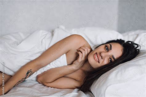 Sexy Happy Nude Beautiful Brunette Girl Smiling In Bed Under A Blanket In Bedroom Stock Photo