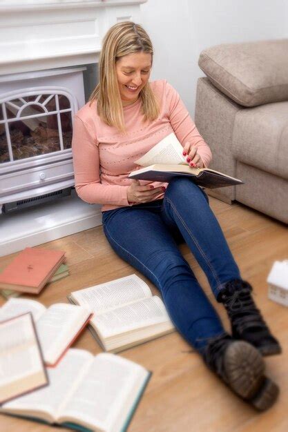 Mujer Sonriente Leyendo Un Libro De Papel Sentado En El Suelo En Casa