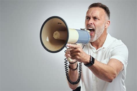 Listen Up Studio Shot Of A Mature Man Using A Megaphone Against A Grey