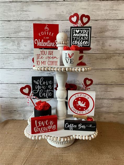 A Three Tiered Cake Decorated With Valentine S Day Cards And Coffee Mugs