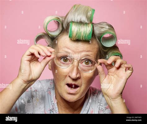 Funny Amazed Surprised Senior Women With Hair Rolls And Glasses On Pink