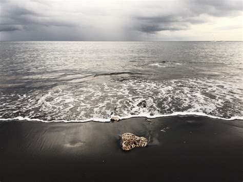 tea-smoked. | Volcanic black sand beach in Amed, Bali. The most...