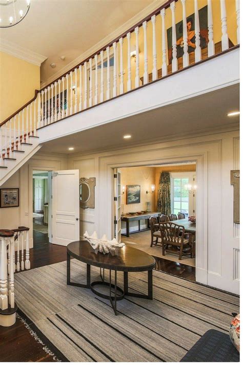 Spacious Two Story Foyer With Landing Yellow Walls Dark Wood Floor