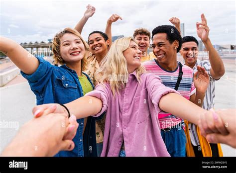 Happy Young Friends Holding Hands And Having Fun Together Stock Photo