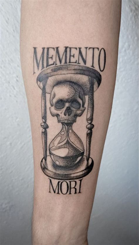 A Tattoo On The Leg Of A Man With An Hourglass And Skull In It