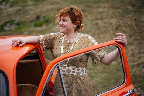 Young Ginger Woman Standing Next To The Vintage Car Del Colaborador De Stocksy Boris