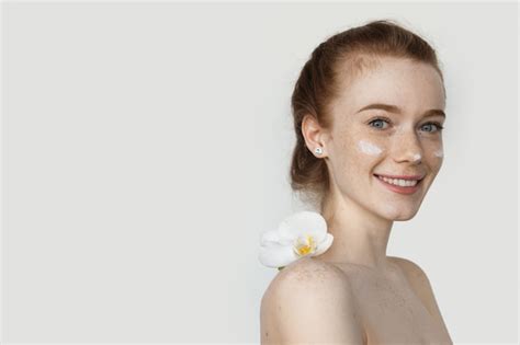 Premium Photo Red Haired Woman With Freckles Is Posing With A Flower On Naked Shoulders And
