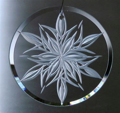 A Glass Ornament With A White Snowflake In The Center On A Black Background