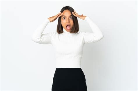 Mujer latina joven aislada en la pared blanca con expresión de sorpresa Foto Premium