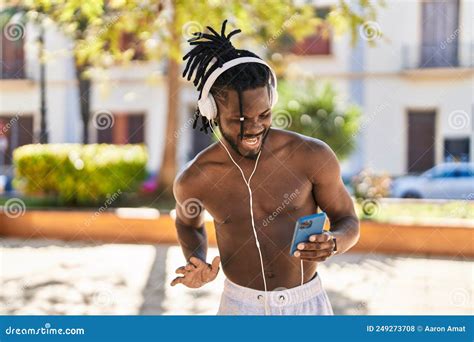 African American Woman Shirtless Listening To Music And Dancing At Park