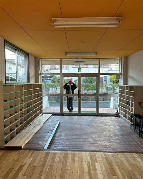 A Man Standing In The Doorway Of A Building With Lots Of Shelves On