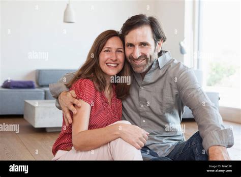 Mature Couple Sitting On Floor Of Living Room Stock Photo Alamy