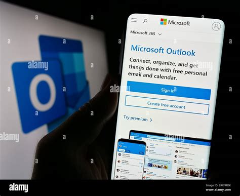 Person Holding Cellphone With Webpage Of Email Software Microsoft