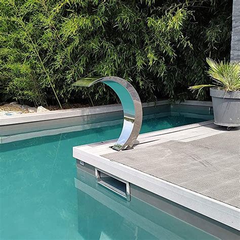 A Swimming Pool With An Artistic Sculpture In The Middle And Green