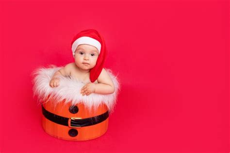 Niño Pequeño De Seis Meses En Un Gorro De Papá Noel Se Sienta En Una