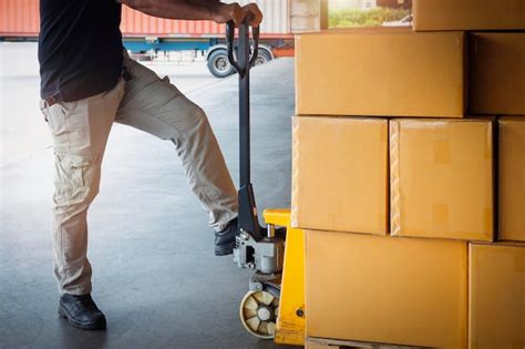 Premium Photo Workers Unloading Package Boxes On Pallets In Warehouse